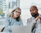 Two people looking at information on laptop screen
