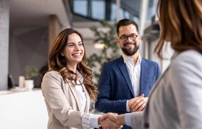 Two people shaking hands after completing a deal