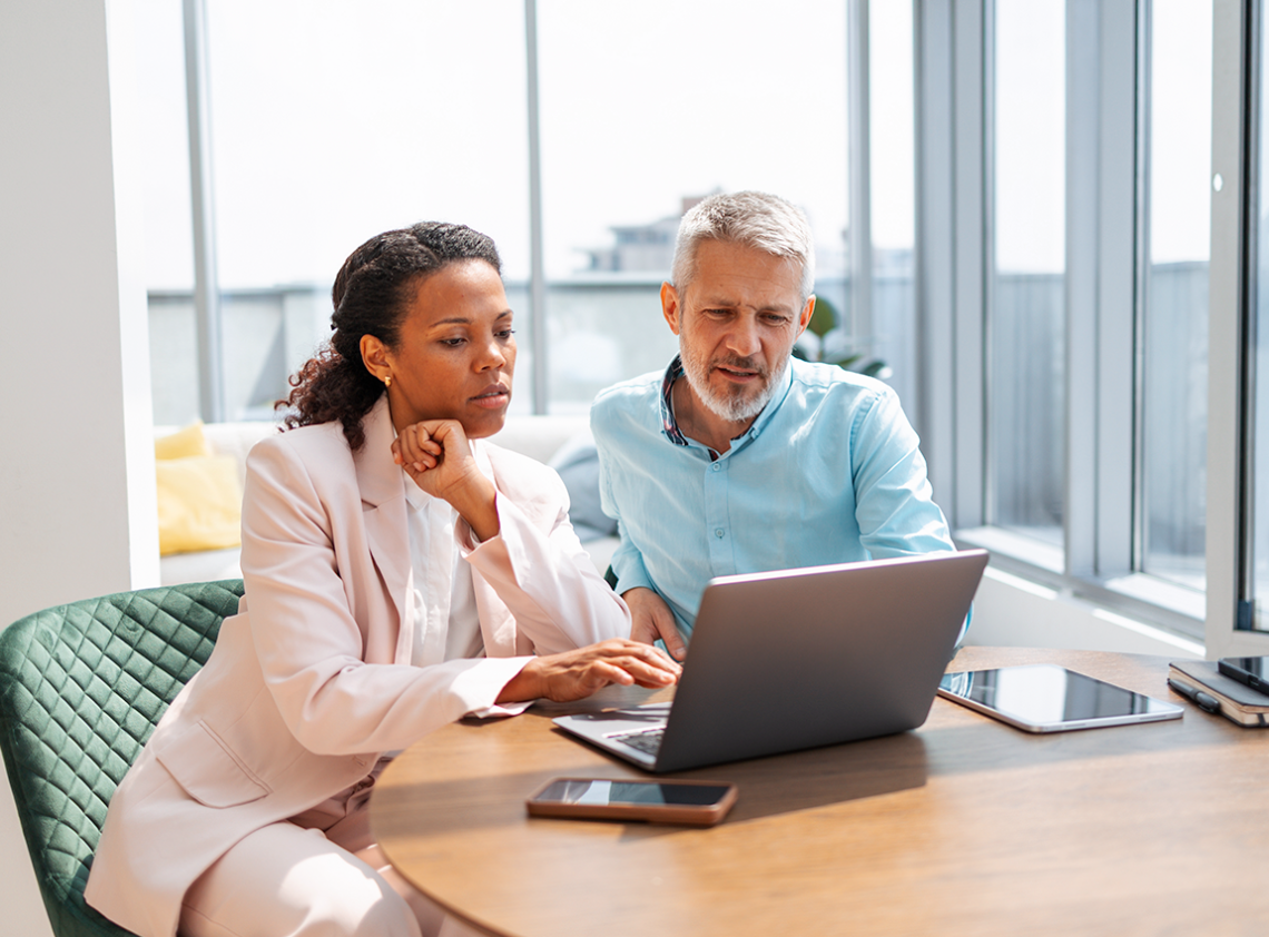 A couple reviewing documents on their laptop