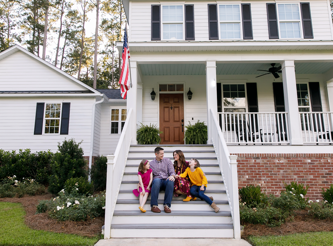 Family sitting on stairs outside their home