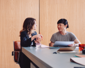 Two females discussing at a table