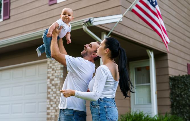 Couple holding a baby and American Flag