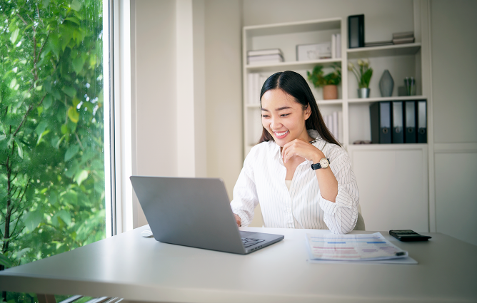 Female looking at her laptop at her desk at home