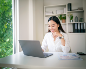 Female looking at her laptop at her desk at home