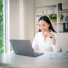 Female looking at her laptop at her desk at home