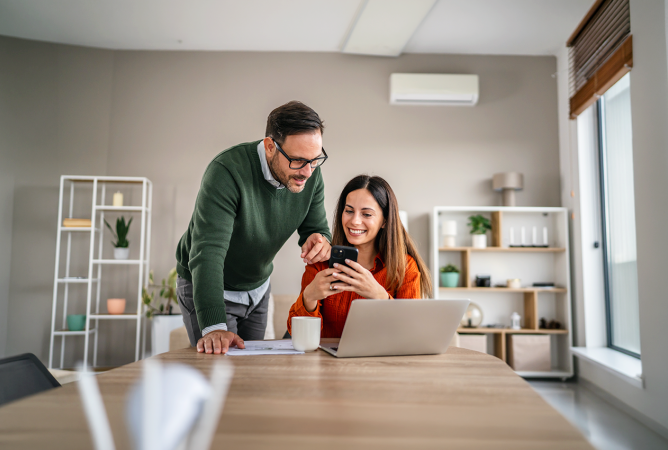 A couple reviewing information on their laptop on their kitchen table