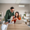 A couple reviewing information on their laptop on their kitchen table